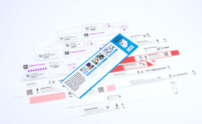 An assortment of Zebra wristbands, including Z-Band Fusion, Z-Band QuickClip, and Z-Band Direct, showcasing durable, customizable options with barcodes and patient identification for healthcare and event management applications.